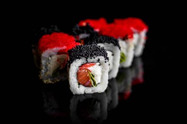 Taze ve lezzetli suşi siyah arka planda izole edilmiş..