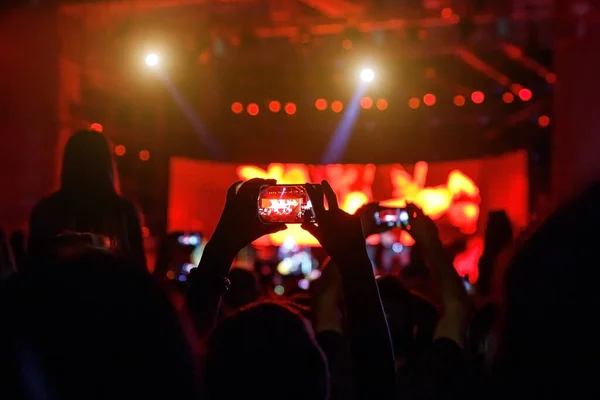 People at concert shooting video or photo by smartphone