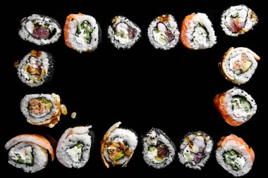 Somon, ton balığı, salatalık ve yeşil soğanlı suşi ruloları.