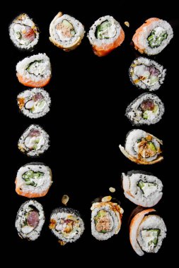 Farklı dolgulu geleneksel Japon suşisi. Üst manzara, siyah arkaplan. Metin için boşluk