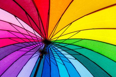 Renkli gökkuşağı şemsiyesinin altında, yağmur damlaları arkaplan