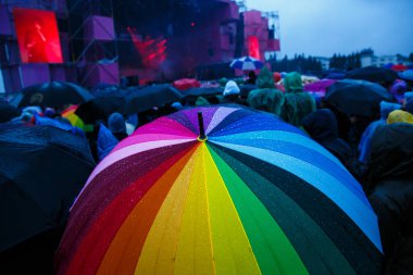 Yağmurlu açık hava yaz festivalinde renkli gökkuşağı şemsiyesi
