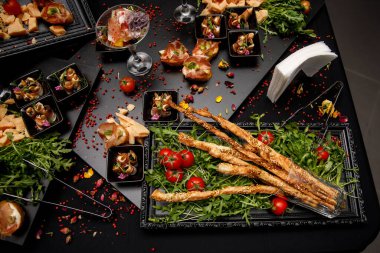 Gurme aperatifler, etkinlikte yemek servisi, masada farklı atıştırmalıklar..