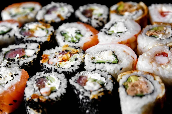 Sushi on a black background. Sushi set on a table. Top view. Asian or Japanese food. Sushi restaurant concept
