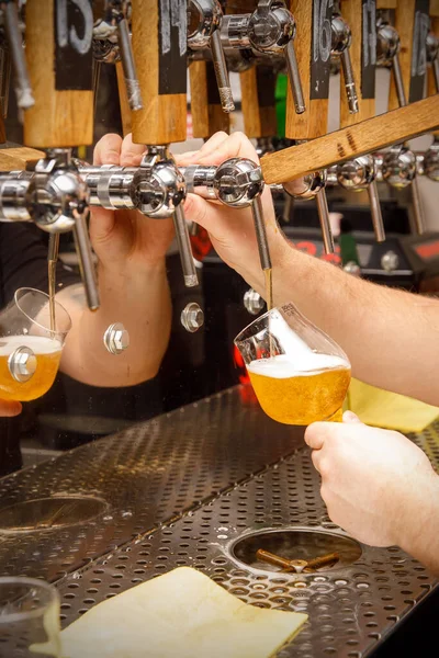 Stock image Bartender, Barman hand at beer tap pouring draught craft beer into tulip glass