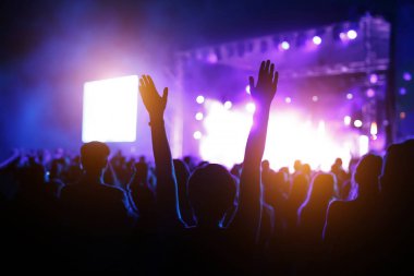 İnsanlar müzik programında dans ediyor. Kaldırılmış elli kız..