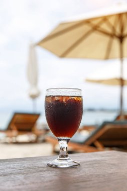 Plajda şemsiyeli kola bardağı. Yazın serin bir içki..
