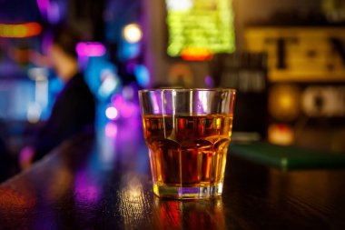 Barın arkasında bir bardak viski.