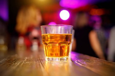 Barın arkasında bir bardak viski.