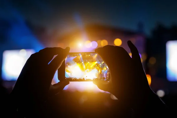 Hands with a smartphone record live music festival, live concert, live concert.
