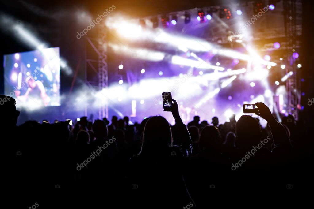 Hand with a smartphone records live music festival, Taking photo of concert stage, live concert, music festival