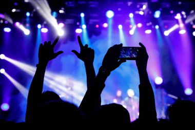 Cep telefonu kamerasıyla bir konser çekiyoruz, sahnenin mavi ışığı.
