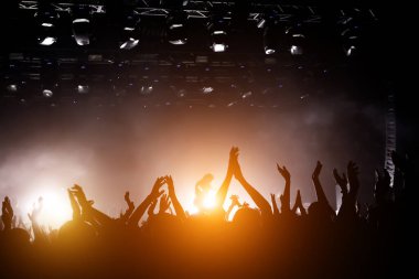 Popüler bir grubun performansı. Kalabalık dans ediyor ve eğleniyor. Mutlu insanların elleri