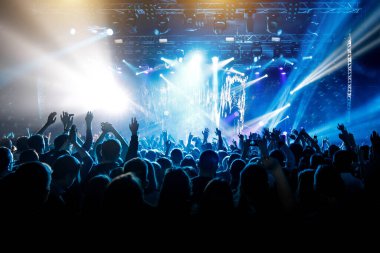 Bir sürü el, konserde kalabalık, mavi ışık