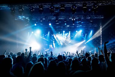 Bir sürü el, konserde kalabalık, mavi ışık