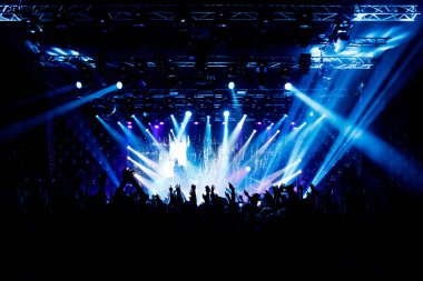 Bir sürü el, konserde kalabalık, mavi ışık