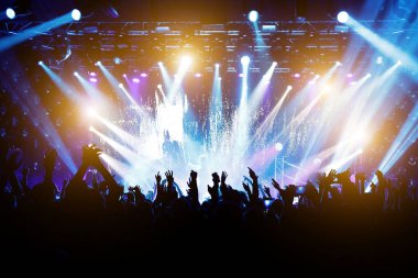Konserdeki memnun insanlar, sahnenin renkli ışığı.