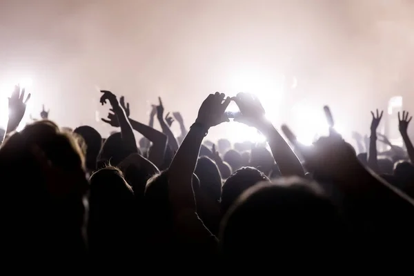 Crowd with raised hands and smartphone record a concert