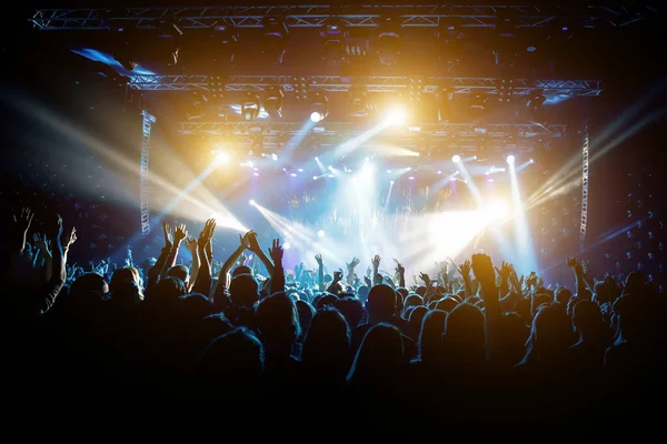 Konserdeki memnun insanlar, sahnenin renkli ışığı.