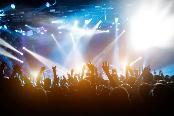 Popüler bir grubun performansı. Kalabalık dans ediyor ve eğleniyor. Mutlu insanların elleri