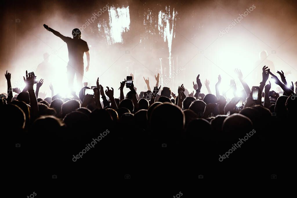 Rock concert. Leader on the stage. Silhouette of the crowd in front of the stage