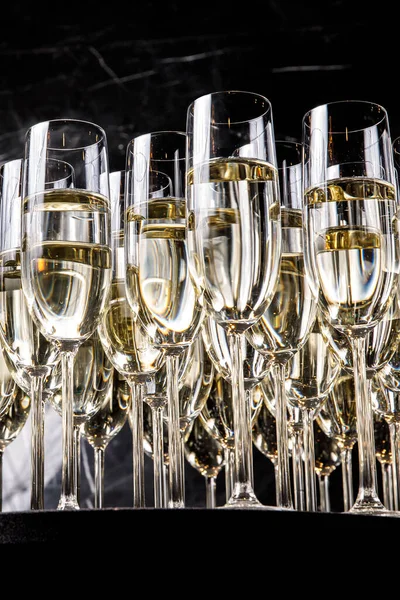 シャンパンが充填されたグラスの列が提供される準備ができて並んでいます ブラックを基調とした高級シャンパングラス — ストック写真