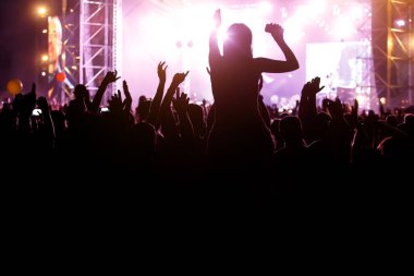 Kalabalığın silueti ve yaz müzik festivalinin karşısındaki kızlar.