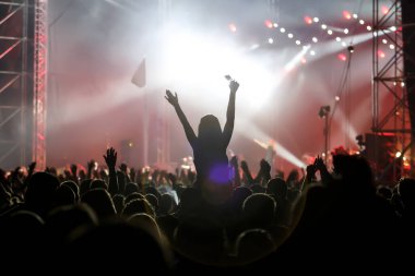 Açık hava müzik fuarında eller havada siluetler