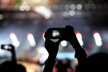 Yaz müzik şovunda hayranların elinde bir cep telefonu. Kayıt konseri