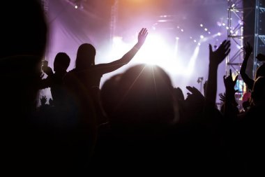 Elleri müzik festivali sahnesinde olan hayranlar