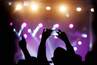 Yaz müzik şovunda hayranların elinde bir cep telefonu. Kayıt konseri