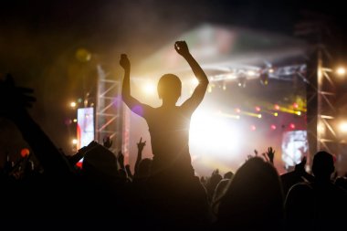 Kalabalığın fotoğrafı, rock konserinden hoşlanan insanlar, ellerini kaldırıp zevk alkışlıyorlar, aktif gece hayatı kavramı..