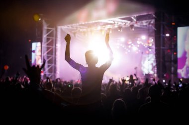 Müzik festivalinde kalabalığın içinde siyah bir kızın silueti omuzlarında.