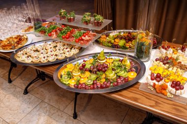 Kurumsal, noel, doğum günü, parti, etkinlik veya düğün kutlamalarında farklı atıştırmalıklar ve aperatiflerle güzel dekore edilmiş yemek ziyafeti masası.