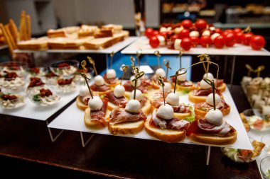 Yemek masası, ziyafette sofraya çeşitli atıştırmalıklar koydu. Soğuk aperatifler, kanepeler, içecekler, yakın çekim..