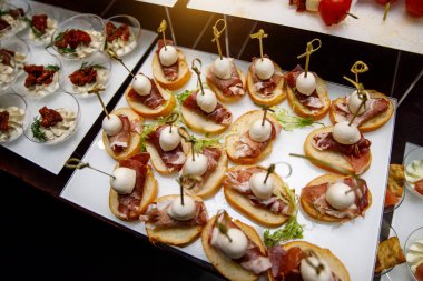 Yemek masası, ziyafette sofraya çeşitli atıştırmalıklar koydu. Soğuk aperatifler, kanepeler, içecekler, yakın çekim..