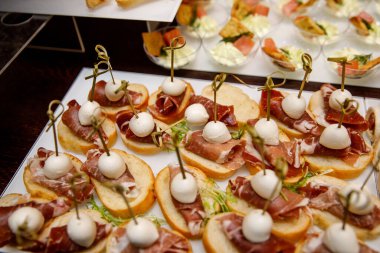 Yemek masası, ziyafette sofraya çeşitli atıştırmalıklar koydu. Soğuk aperatifler, kanepeler, içecekler, yakın çekim..