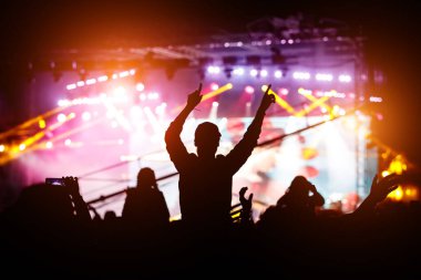 Müzik festivali ya da konserden hoşlanan bir kız. Kalabalığın siyah silueti