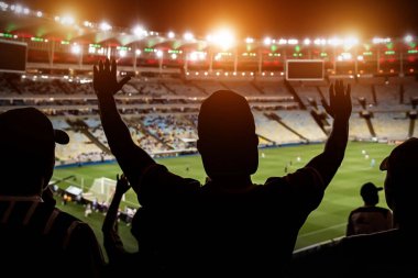 Futbol taraftarları kalabalık futbol stadyumunda takımı destekliyor