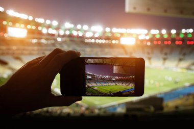 Stadyumdaki futbol maçını fotoğraflayan akıllı telefon..