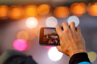Adam konserde video çekmek için akıllı telefon kullanıyor..