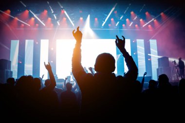 Elleri havada bir adam müzik gösterisinden hoşlanıyor. Konserde mutlu kalabalık