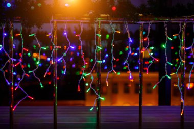 Karanlık arka planda çok renkli çelenkler, yılbaşı ışıkları