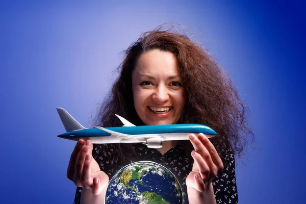 在地球上空抱着飞机模型的女孩 航空公司帮助的概念 — 图库照片#