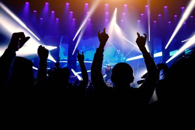 Elleri havada bir adam müzik gösterisinden hoşlanıyor. Konserde mutlu kalabalık