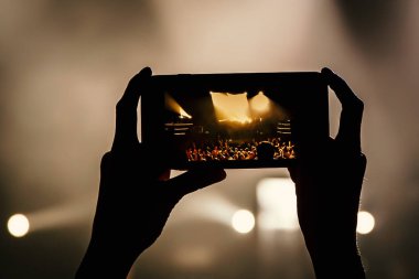 Bir müzik gösterisinde cep telefonu elinde. Akıllı telefon kavramını kullanarak.