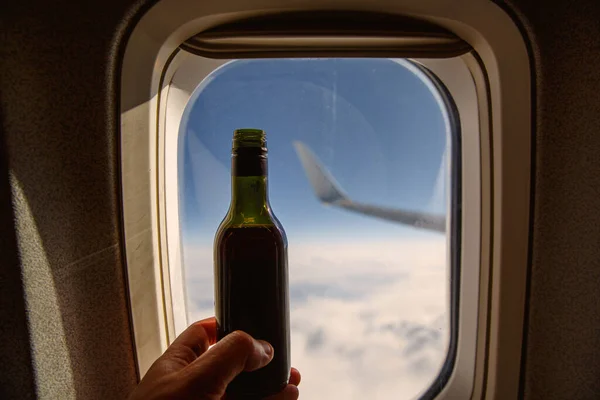 Una Botella Vino Frente Ojo Buey Alcohol Bordo Avión —  Fotos de Stock