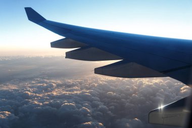 Gün batımında bulutların üstünde uçak kanadı