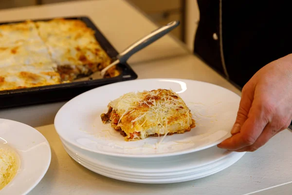 Cook Met Morceau Lasagne Fraîche Sur Une Assiette Blanche — Photo