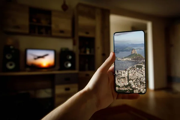 stock image Concept of travel on a smartphone. Stay at home tourism. Online travel to Rio-De-Janeiro. Sugarloaf on a screen.